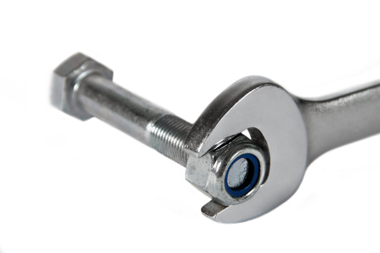 Wrench gripping a nut, illustrating the application of torque